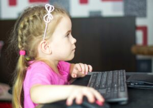 Pieni tyttö pelaa tietokoneella