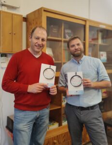 Two men holding a new book